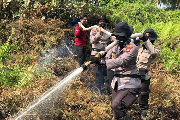 Tiga personel Polwan Polres Inhil saat berjibaku memadamkan titik api karhutla di Desa Sungai Teritip, Kecamatan Kateman, Kabupaten Inhil, Riau, Senin (16/3/2020).