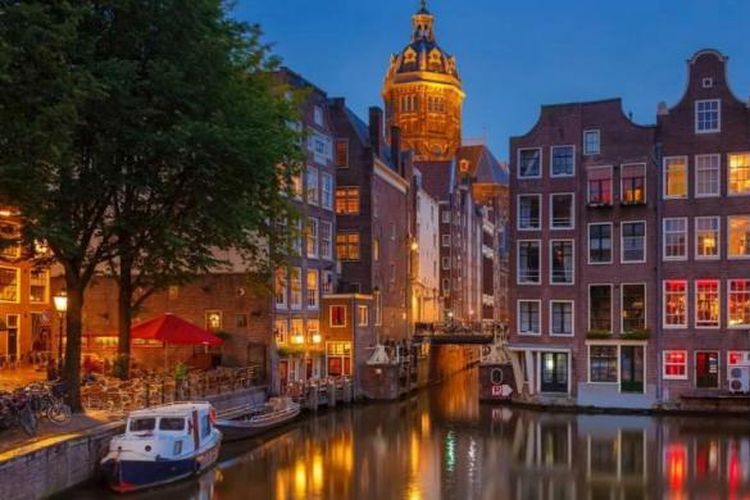 Rumah-rumah di pinggir kalan di kota Amsterdam, Belanda saat senja.