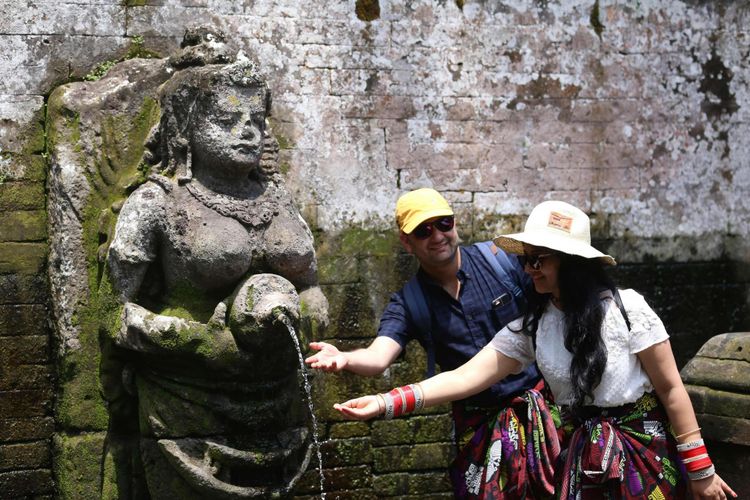 Para wisatawan mengunjungi Arca Widyadhari pancuran di kolam pemandian sakral Goa Gajah, Kabupaten Gianyar, Bali, Senin (2/4/2018). Goa Gajah merupakan salah satu destinasi wisata di Bali yang banyak dikunjungi wisatawan baik asing maupun domestik.