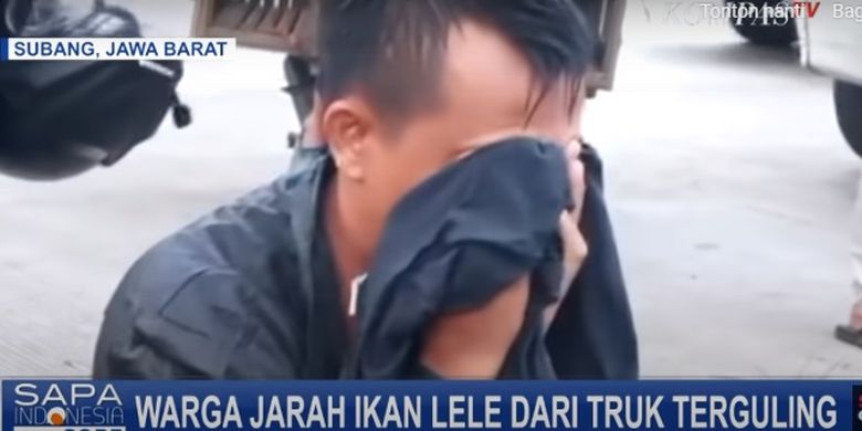 Edi, pengemudi truk lele hanya bisa menangis di pinggir sawah melihat lele yang dibawanya dijarah oleh warga.