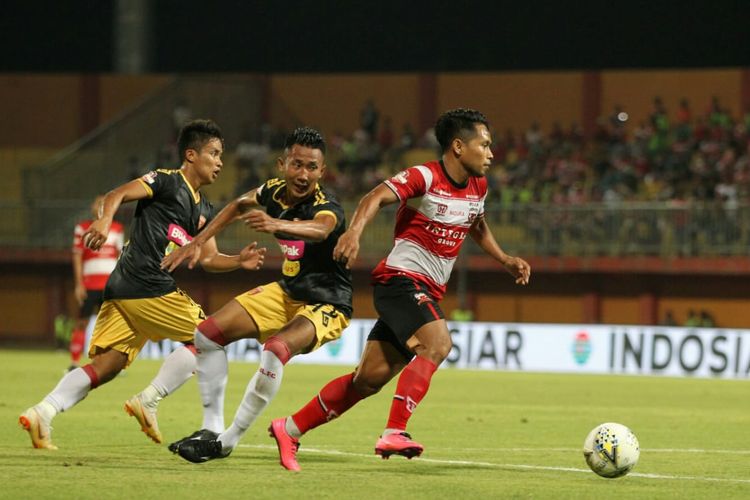 Pemain sayap Madura United, Andik Vermansah (paling depan), memggiring bola melewati dua pemain Perseru Badak Lampung pada laga pekan ke-11 Liga 2010 di Stadion Gelora Ratu Pamelingan, Sabtu (27/7/2019). Pertandingan tersebut dimenangi Madura United dengan skor 5-1. 