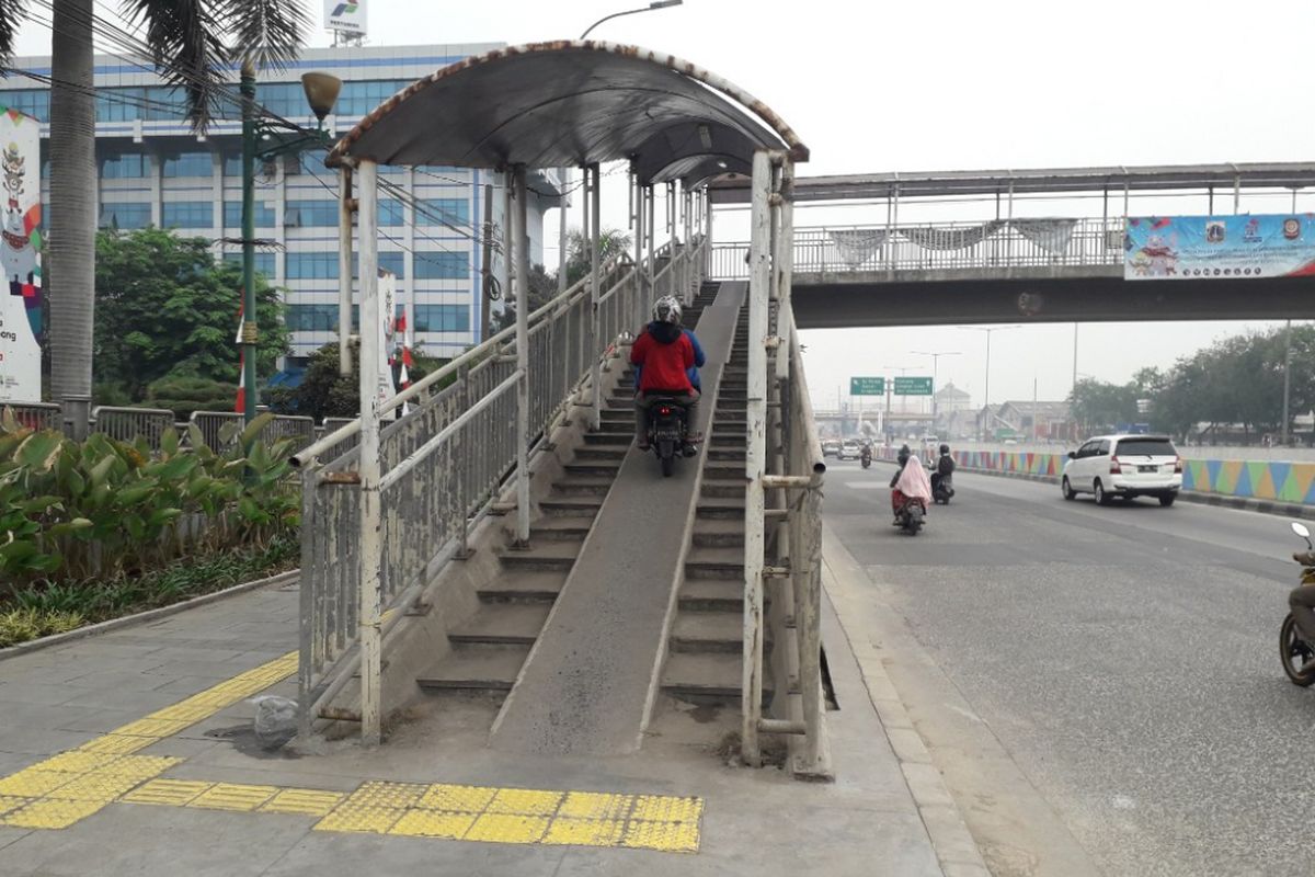 Pengendara sepeda motor nekat melintasi Jembatan Penyeberangan Orang (JPO) Ampera di Jalan Yos Sudarso, dekat Kantor Wali Kota Jakarta Utara, Rabu (8/8/2018).