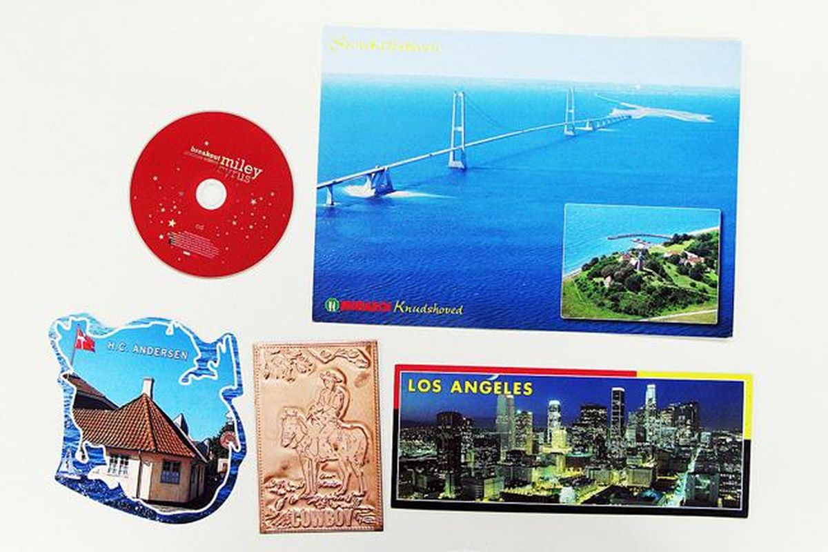 Aneka bentuk dan ukuran kartu pos dibandingkan dengan sebuah cakram kompak (CD). Salah satu kartu pos terbuat dari tembaga.