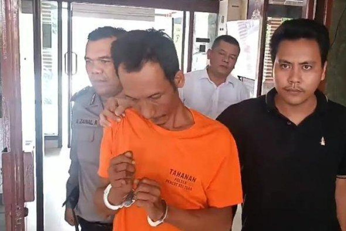 Tampang Sulaiman Purba, pembakar wanita pemilik rumah makan, Herlinda Gurusinga, saat digiring oleh petugas memasuki sel tahanan di Mapolsek Medan Tembung, Medan, Senin (20/5/2024). 
