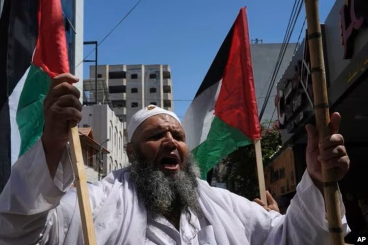 Seorang warga Palestina membawa bendera negaranya dalam aksi solidaritas terhadap Yerusalem, di Khan Younis, Jalur Gaza, pada 9 September 2022.