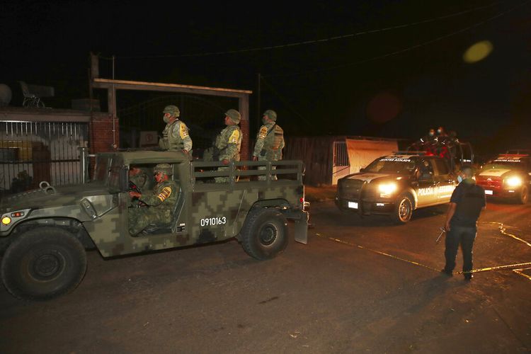Petugas keamanan bersenjata berat masuk ke daerah di mana lebih dari selusin petugas penegak hukum tewas setelah konvoi mereka disergap oleh pria bersenjata, memicu perburuan besar-besaran oleh polisi, Marinir. dan Garda Nasional di Coatepec Harinas, negara bagian Meksiko, Kamis (18/3/2021). 