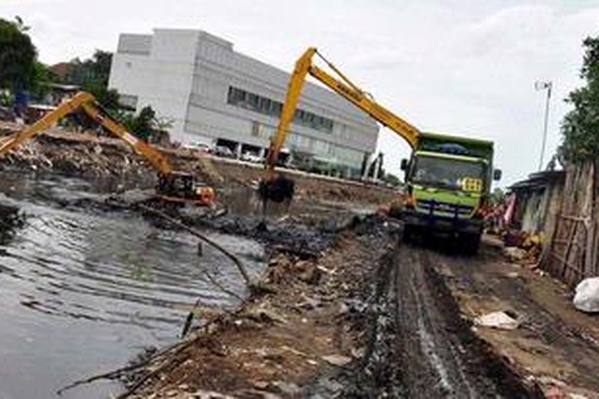 Eskavator dan truk digunakan untuk mengeruk lumpur dan sampah pada proyek normalisasi kali Pakin, Penjaringan, Jakarta Utara, Senin (18/2/2013). Untuk mengantisipasi banjir di Pluit, Pemprov DKI Jakarta berencana akan memperdalam kali pakint hingga 5 meter, dari sebelumnya yang hanya sedalam 1,5 meter. KOMPAS IMAGES/ANDREAN KRISTIANTO
