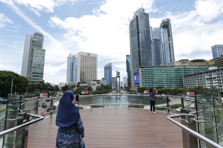 Pengunjung berfoto di anjungan Halte Transjakarta Bundaran Hotel Indonesia, Jakarta, Jumat (28/10/2022). Warga Ibu Kota datang ke halte yang belum sepenuhnya rampung itu untuk antre berfoto demi dapat latar belakang Patung Selamat Datang.