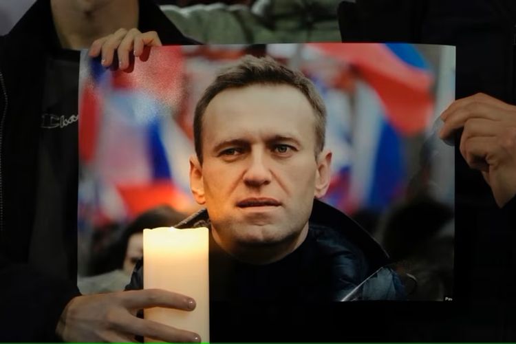 Para pengunjuk rasa memegang foto Alexei Navalny saat melakukan demonstrasi di seberang Kedutaan Besar Rusia di London, Jumat, 16 Februari 2024.