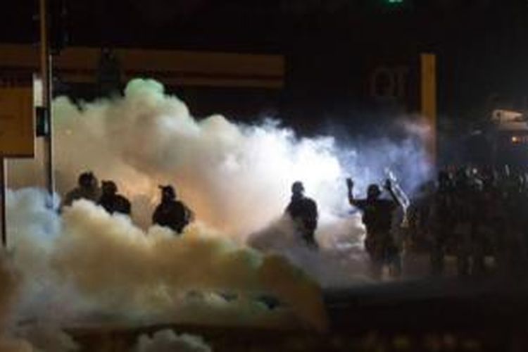 Polisi anti huru-hara membubarkan demonstran di Ferguson, Missouri.