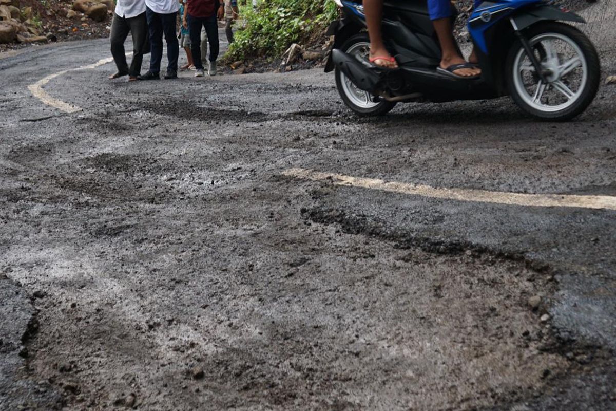 Kondisi jalan di Desa Pakisan dan Desa Tambakan, Kecamatan Kubutambahan, Kabupaten Buleleng, Provinsi Bali, yang rusak padahal baru diperbaiki, Rabu (14/5/2025).