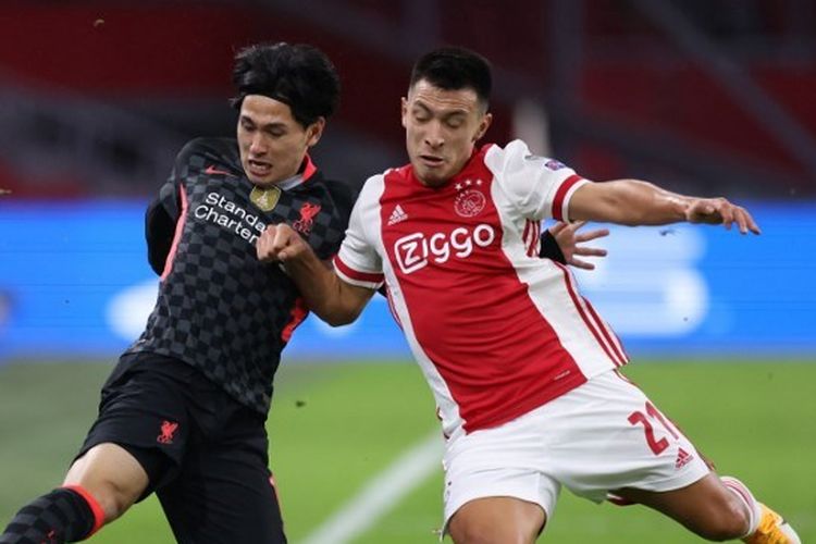 Bek Ajax Amsterdam, Lisandro Martinez (kanan) berduel dengan penyerang Liverpool, Takumi Minamino, dalam laga fase grup Liga Champions 2020-2021 di Amsterdam Arena, 21 Oktober 2020.