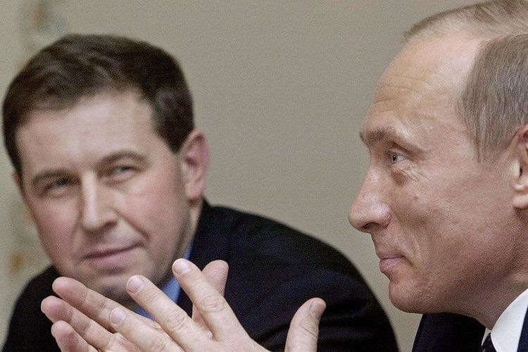 Dr Andrei Illarionov (kiri) terlihat sedang menyaksikan Presiden Rusia Vladimir Putin memberikan pidato pada tahun 2004. 