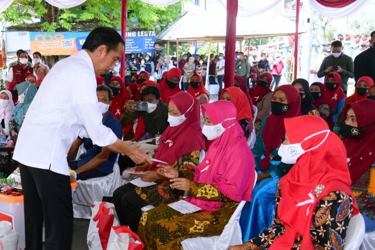 Presiden Joko Widodo saat menyerahkan bansos kepada para pedagang di Pasar Larangan, Kabupaten Sidoarjo, pada Senin (22/8/2022).