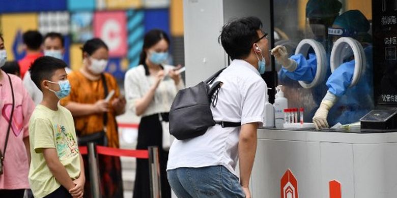 Seorang petugas kesehatan mengambil sampel swab dari seorang pria untuk diuji virus corona Covid-19 di Kota Chengdu, di provinsi Sichuan barat daya China pada 1 September 2022. 