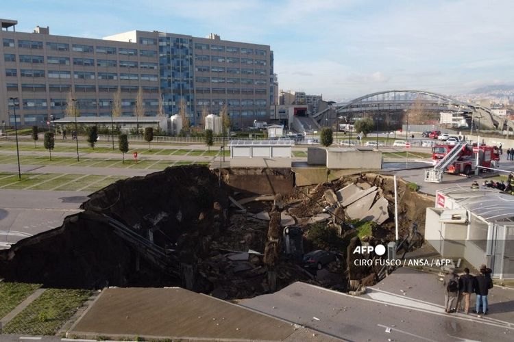 Lubang besar yang menganga akibat amblesnya tempat parkir mobil rumah sakit Ospedale del Mare, di Naples, Italia, pada Jumat (8/1/2021), yang menelan sejumlah mobil.