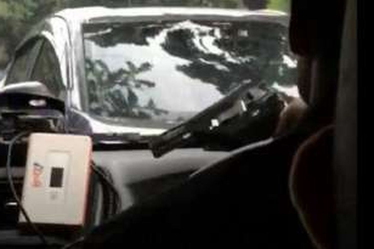 Foto yang beredar di Facebook yang memperlihat seorang sopir Go-Car yang mengendara mobilnya sampil memegang sesuatu yang mirip pistol. 