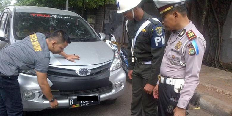 Pelepasan stiker TNI yang dipasang di plat nomor.