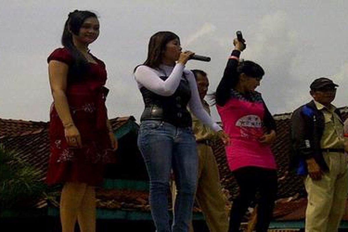 Tiga penyanyi dari Kendal, tampil menghibur ribuan pamong dan kepala desa yang melakukan aksi unjuk rasa di tepi jalur pantura Kendal, Jawa Tengah, Kamis (12/1/2012) untuk menuntut pengesahan RUU tentang desa.