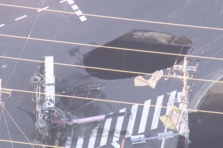 Tangkapan layar dari tayangan stasiun televisi memperlihatkan dua sinkhole muncul di jalan Kota Yashio, Prefektur Saitama, Jepang, Selasa (28/1/2025).