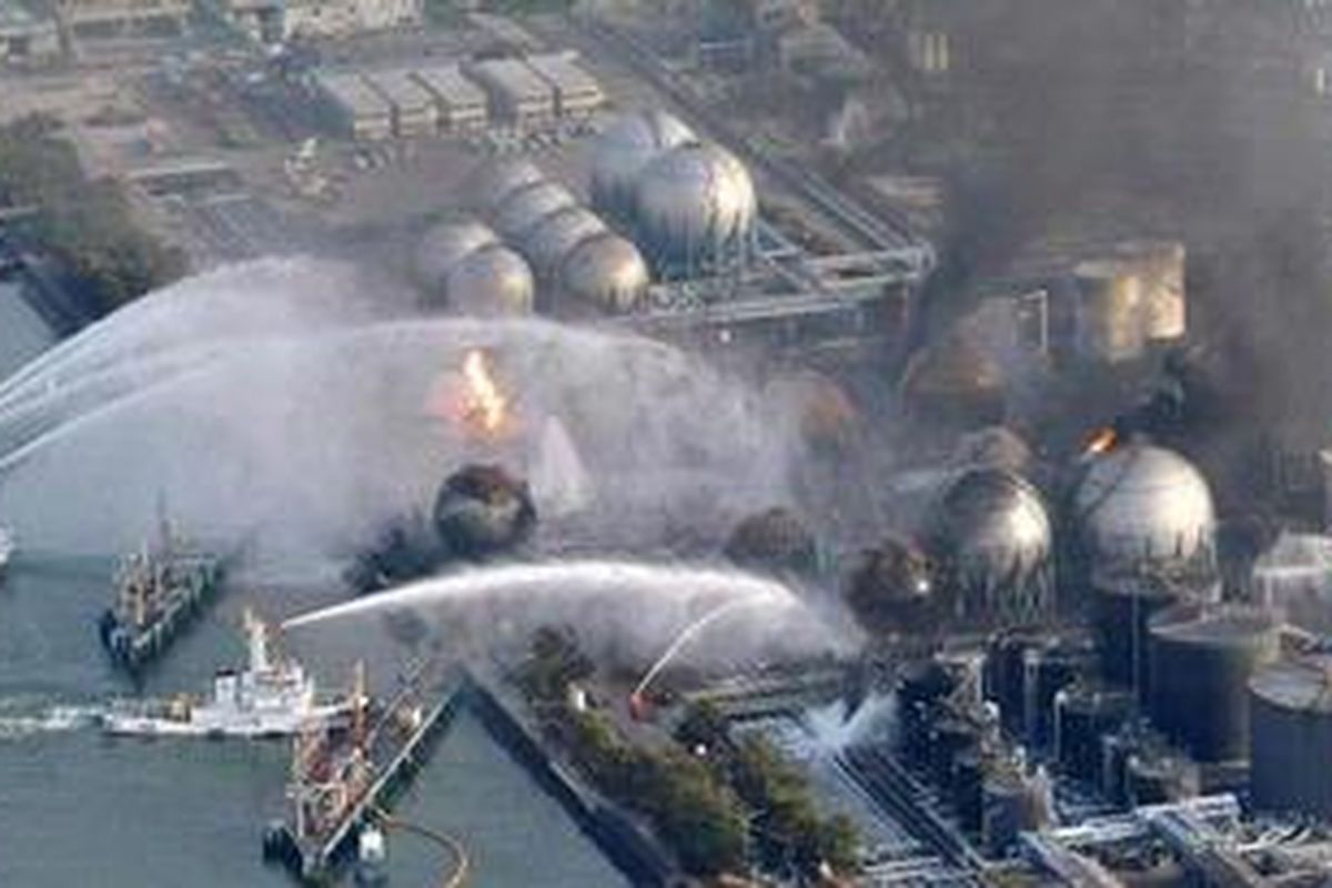 Kapal-kapal pemadam kebakaran menyemprotkan air ke tangki-tangki kilang minyak yang terbakar di Ichihara di Prefektur Chiba, di timur Tokyo.