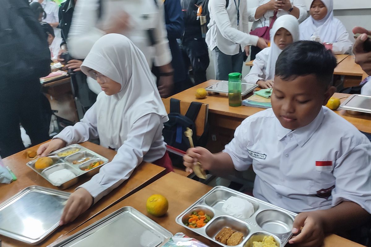 Siswa SD Susukan 01 ketika membuka makan bergizi gratis di SDN 01 Susukan, Ciracas, Jakarta Timur. 