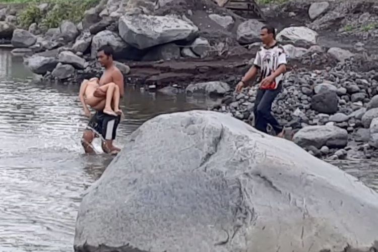 Warga melakukan evakuasi terhadap dua anak yang tenggelam di sungai, Minggu (14/8/2022)