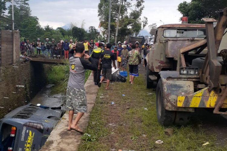 Aparar kepolisian mengamankan lokasi kecelakaan dan berupaya mengevakuasi elf yang masuk selokan, Jumat (27/03/2020) pagi (foto : handout Satlantas Polres Garut)