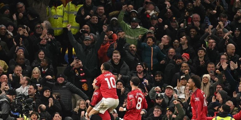 Diogo Dalot dikerumuni oleh rekan satu timnya setelah mencetak gol pembuka dalam pertandingan sepak bola Liga Inggris antara Manchester United vs West Ham United di Old Trafford di Manchester, barat laut Inggris, pada 4 Desember 2025. (Foto oleh Oli SCARFF / AFP) 