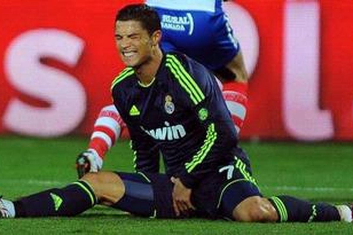 Penyerang Real Madrid dari Portugal, Cristiano Ronaldo, bereaksi kesakitan dalam laga Liga BBVA melawan Granada di Stadion Nuevo Los Carmenes, Sabtu (2/2/2013). Madrid akhirnya kalah 0-1 akibat gol bunuh diri Ronaldo. 