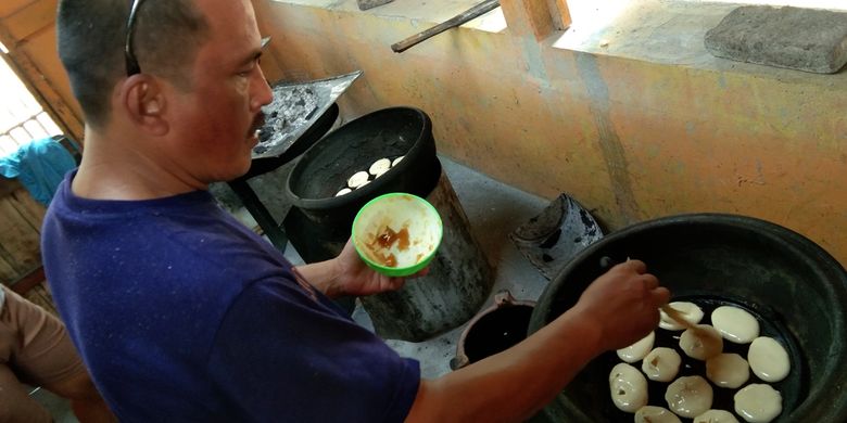 Yayat tengah memasukkan adonan Bolu Kijing  ke dalam panggangan, Kamis (7/11/2019). Bolu Kijing buatan Keluarga Yayat diproduksi secara tradisional untuk menjaga citarasanya.