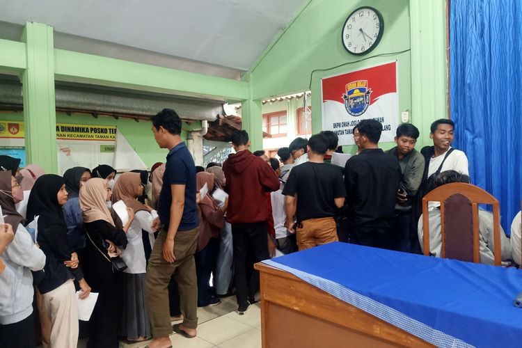 Ratusan karyawan pabrik garmen rela mengantri hingga malam untuk mendapatkan gaji 40% di Balai Desa Kabunan, Pemalang, Jawa Tengah