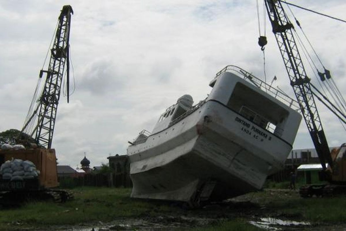 Sebuah kapal terdampar di lapangan yang jauh dari laut setelah tersapu tsunami Aceh, 26 Desember 2004 silam. Foto diambil setahun setelah kejadian.