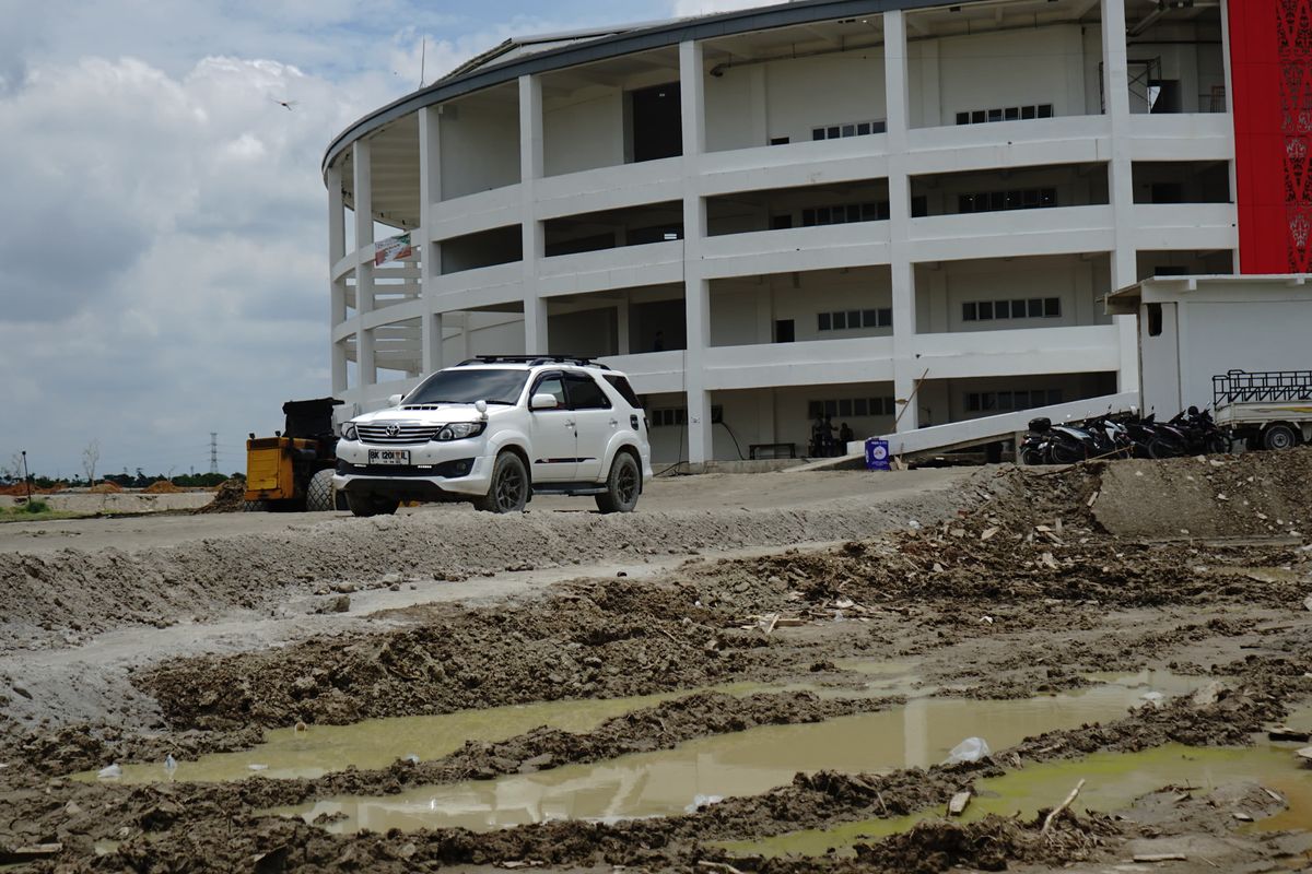 Suasana di bagian kiri dan kanan jalan menuju venue Bola Voli Indoor masih becek dan terdapat genangan air, di kawasan Sport Center Sumut, di Desa Sena, Kabupaten Deli Serdang. 