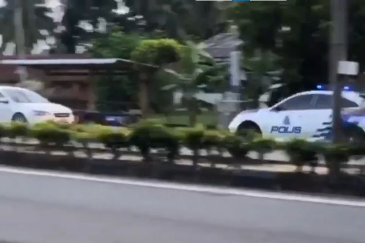 Tangkapan layar dari video sedan putih Proton Inspira yang melaju mundur dan dikejar mobil patroli polisi, di Terengganu, Malaysia, pada Jumat (11/12/2020).