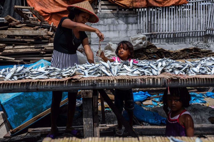 Pekerja menjemur ikan di pusat pengolahan ikan, Muara Angke, Jakarta Utara, Kamis (22/10/2020). Harga sejumlah komoditas ikan asin beranjak naik karena pasokan menurun dan ditambah datangnya musim hujan yang memperlama waktu penjemuran ikan.