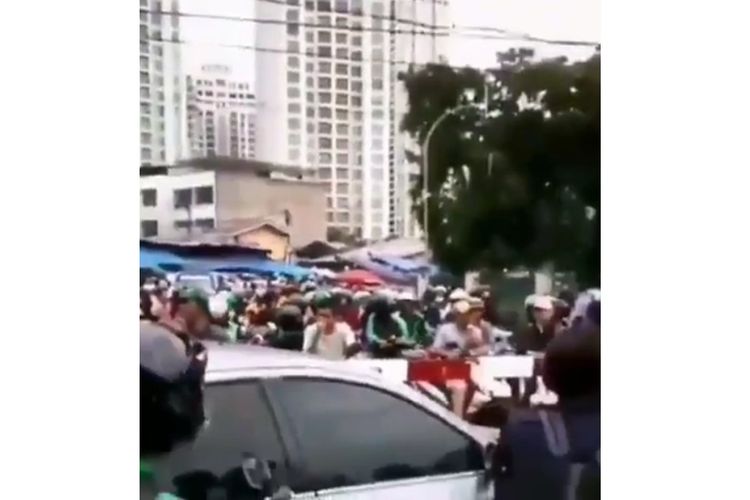 Tangkapan layar dari sebuah video yang memperlihatkan para pengendara motor terjebak di dalam perlintasan kereta saat palang sudah tertutup.