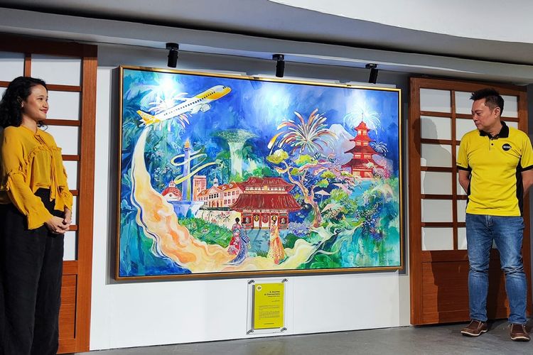 Seniman Rachel Ajeng (kiri) dan General Manager Indonesia of Scoot Johanes Ong berpose bersama lukisan bertajuk A Journey of Connections yang bercerita tentang perjalanan ke Tokyo. Lukisan akan dipajang di MoJA Museum Jakarta hingga 22 Oktober 2023.