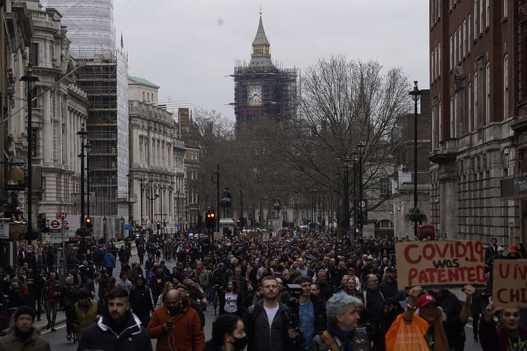 Pengunjuk rasa anti-lockdown berbaris menentang pembatasan virus corona yang sedang berlangsung di pusat kota London pada 20 Maret 2021.
