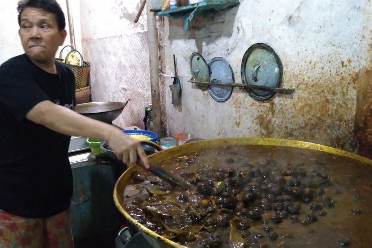 Lani memasak keong di rumah sekaligus warung Jalan Kauman Lama, Purwokerto, Jawa Tengah, Sabtu (11/5/2019)