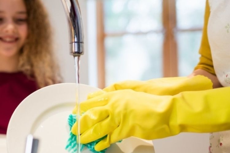 Ilustrasi mencuci piring menggunakan sarung tangan karet