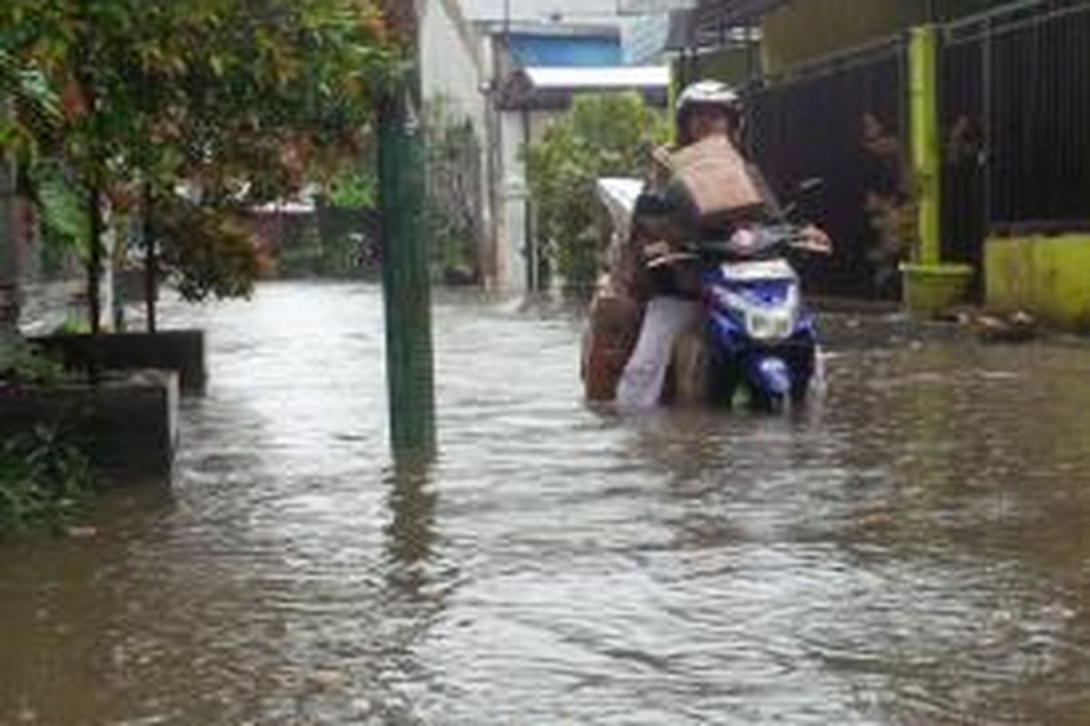 Seorang pengendara motor kebingungan di tengah banjir karena motornya mogok di Jalan Dana Karya, Kampung Gedong, Pasar Rebo, Jakarta Timur, Sabtu (22/2/2014).