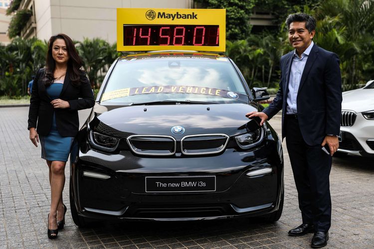 Presiden Direktur Maybank Indonesia, Taswin Zakaria dan Jodie Otania sebagai Direktur komunikasi, BMW Group Indonesia foto bersama di samping mobil New BMW i3s dalam konferensi pers di Gedung Sentral Senayan 3, Jakarta, Selasa (20/8/2019). Maybank Bali Marathon 2019 juga menggandeng BMW sebagai Official Automotive Partner untuk event ini.