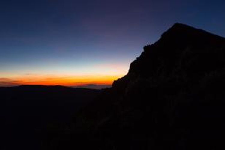 Matahari terbit dari belakang kaldera Gunung Tambora, Dompu, Nusa Tenggara Barat, Senin (23/3/2015). Kaldera memiliki luas diameter 7 kilometer yang terbentuk akibat letusan dahsyat pada tahun 1815.