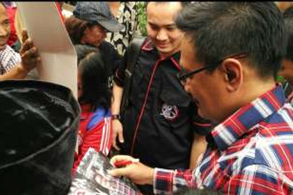 Calon wakil gubernur DKI Jakarta Djarot Saiful Hidayat menandatangani kalender berisi visi-misi Ahok-Djarot saat blusukan di Kelurahan Kota Bambu Utara, Palmerah, Jakarta Barat, Kamis (24/11/2016).