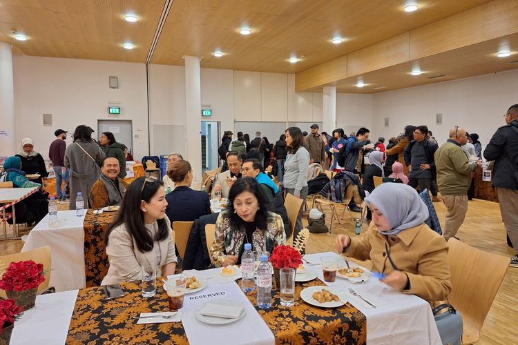 Sejumlah WNI dan warga setempat menyantap hidangan yang disediakan bazar makanan di TPS Mattenhofsaal, Guemligen, desa di pinggiran Kota Bern, Swiss, Sabtu (10/2/2024), saat pemungutan suara pemilu Indonesia 2024 digelar.