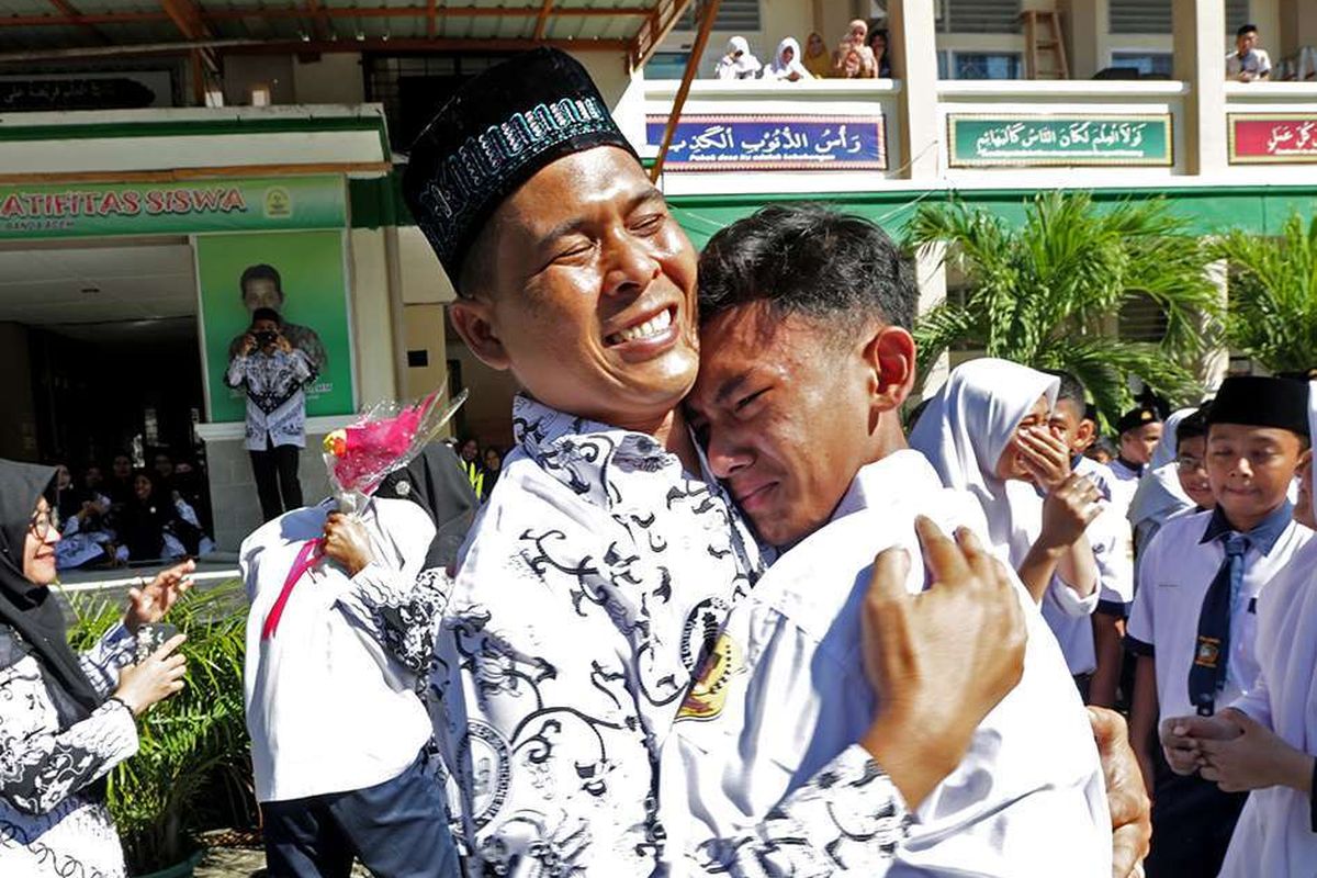 Pelajar memberikan ucapan selamat dengan memeluk gurunya seusai upacara peringatan hari guru nasional dan HUT Persatuan Guru Republik Indonesia (PGRI) di MTsN Model, Banda Aceh, Aceh, Senin (25/11/2019). Peringatan hari guru nasional yang bertepatan dengan HUT ke-74 PGRI menjadi momentum memberikan penghargaan dan ungkapan terima kasih kepada guru yang telah mendidik serta meningkatkan kualitas sumber daya manusia generasi penerus pembangunan bangsa.