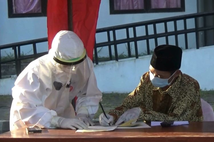 Pasien positif Covid-19 AF, ketika persiapan pelaksanaan akad nikah di halaman wisma atlet tempat isolasi, didampingi satgas covid memakai baju hazmat pada Kamis beberapa hari lalu.