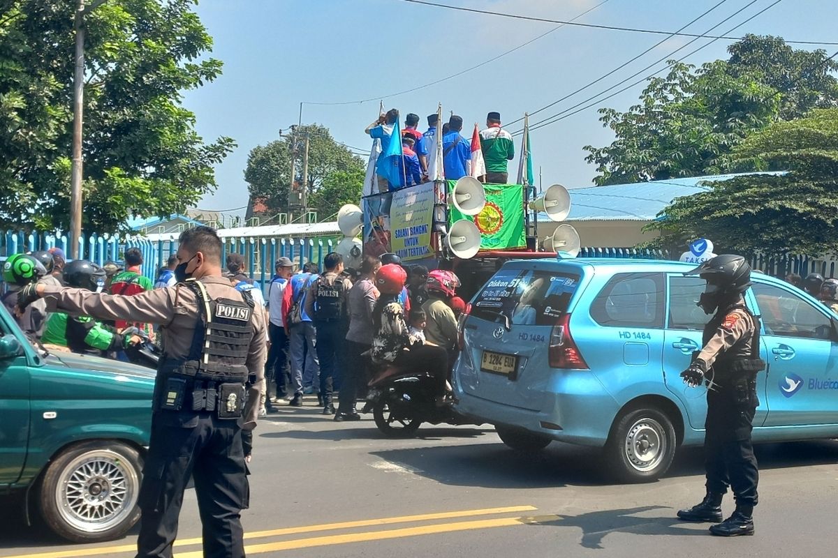 Massa buruh menggelar aksi unjuk rasa di depan PT Tokai Dhaa Indonesia, Jalan Raya Bogor, Depok pada Rabu (31/5/2023). Mereka berdemo karena 74 orang rekannya dipecat secara sepihak.