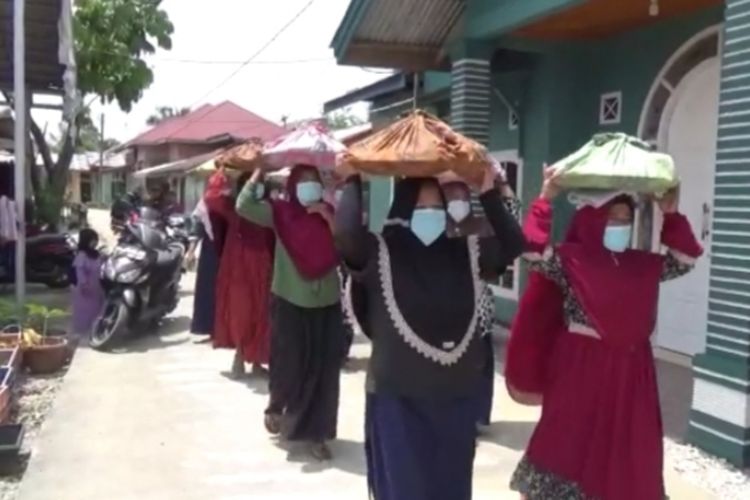 Sejumlah ibu-ibu berjalan beriringan membawa jambau untuk disantap kaum pria pada acara Makan Bajambau menjelang bulan suci ramadan, di Desa Koto Perambahan, Kecamatan Kampa, Kabupaten Kampar, Riau, Jumat (25/3/2022).